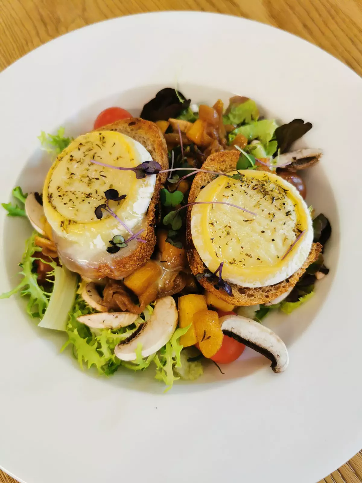 Salade de chèvre de Provence, pain de campagne, pommes rôties au miel, lard grillé, et oignons confits